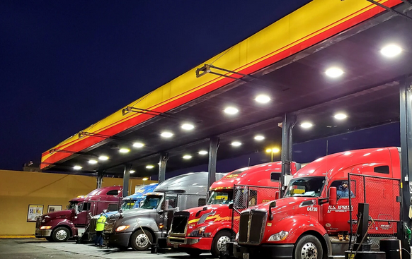 Commercial freight trucks parked at a fuel station representing the growth and vision behind Star Bridge Logistics